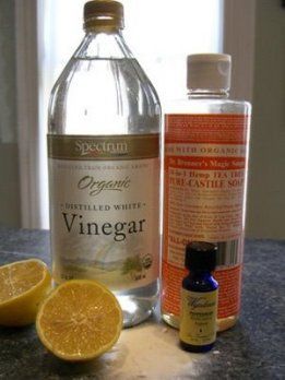 two bottles of vinegar and an orange on a table