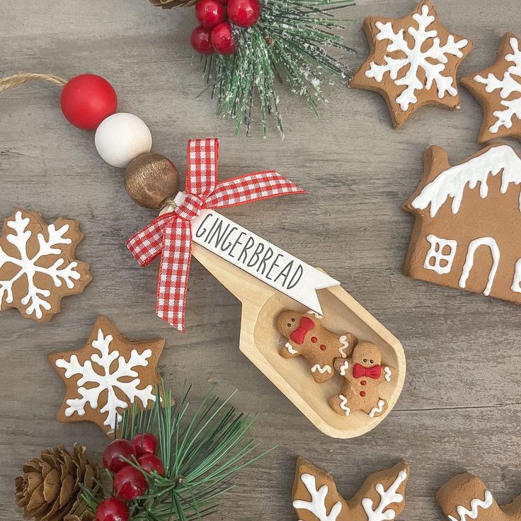 gingerbread cutouts and decorations on a table with pine cones, candy canes, cinnamon sticks, and christmas balls