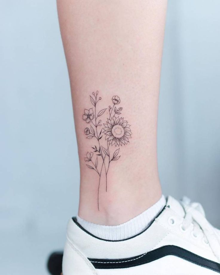 a small flower tattoo on the ankle