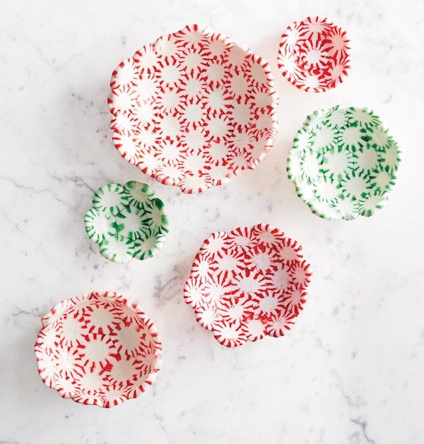 four red and green plates sitting on top of a marble countertop next to each other