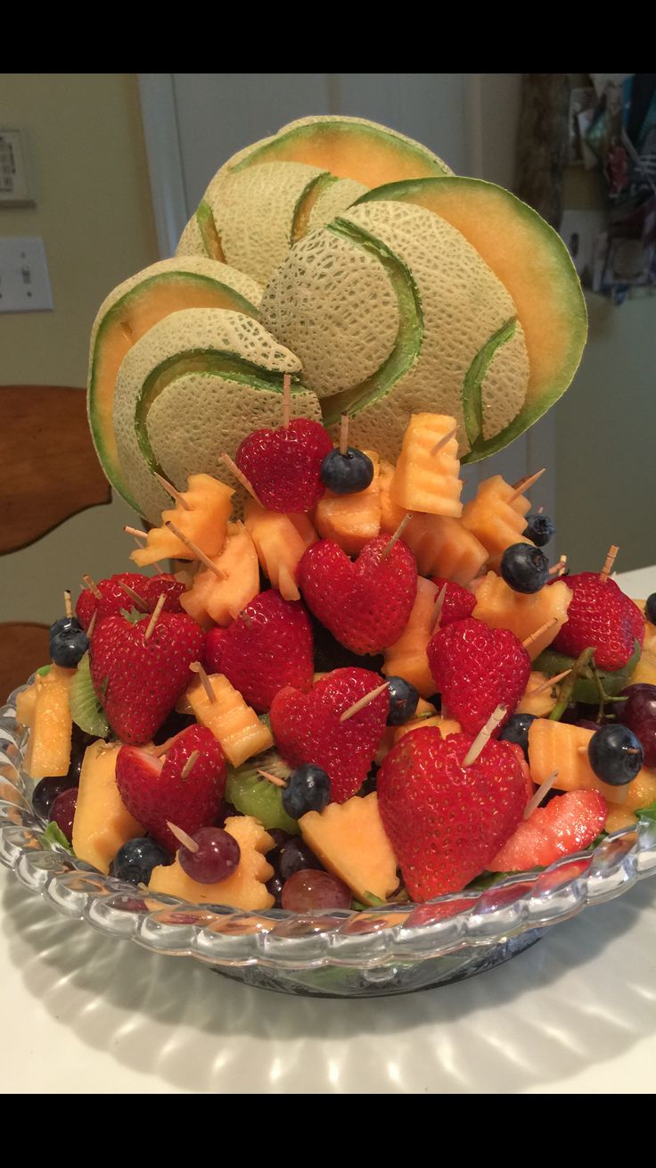 a bowl filled with fruit and cut up kiwis on top of each other