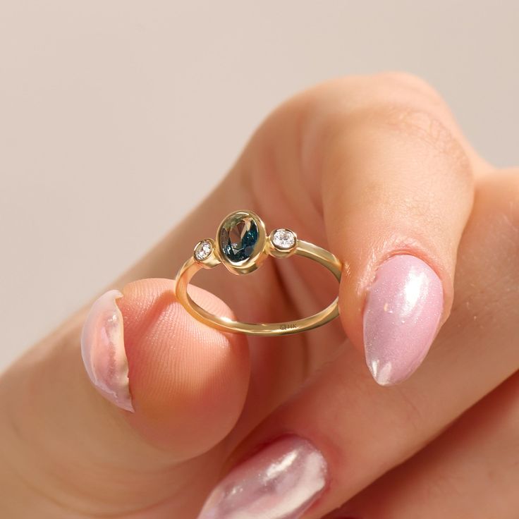 𝐁𝐞𝐳𝐞𝐥 𝐓𝐞𝐚𝐥 𝐒𝐚𝐩𝐩𝐡𝐢𝐫𝐞 𝐑𝐢𝐧𝐠 The Oval Bezel Teal Sapphire Ring is a stunning piece of jewelry crafted in 14k solid gold. This solitaire engagement ring for women features an elegant teal sapphire set in a bezel setting, creating a classic and timeless design. The oval shape of the gemstone adds a touch of sophistication, making it an ideal choice for an anniversary gift. 𝐅𝐞𝐚𝐭𝐮𝐫𝐞𝐬 * Made to Order * Gold KT: 10K, 14K, 18K * Custom Gold Color: Yellow Gold, White Gold, Rose Gold * Side Stones: D-E-F color VVS Clarity Moissanite 0.12ctw * Main Gemstone: Lab Grown Teal Sapphire * Top of Band: 12.05X7.60MM * Width of Band: 1.20MM * Thickness of Band: 1.05MM * Ready to Ship in 5-7 Business Days ✓ We care about the environment, the jewelry we cast is made with recycled gold Gold Sapphire Ring With Gemstone Accents, Teardrop Yellow Gold Sapphire Ring For Anniversary, Yellow Gold Teardrop Sapphire Ring For Anniversary, Teardrop Sapphire Ring In Yellow Gold For Anniversary, Anniversary Yellow Gold Teardrop Sapphire Ring, 14k Gold Oval Birthstone Ring As Gift, Gold Teardrop Sapphire Ring, Yellow Gold Sapphire Topaz Ring As Gift, Oval Rose Gold Birthstone Ring With Bezel Setting