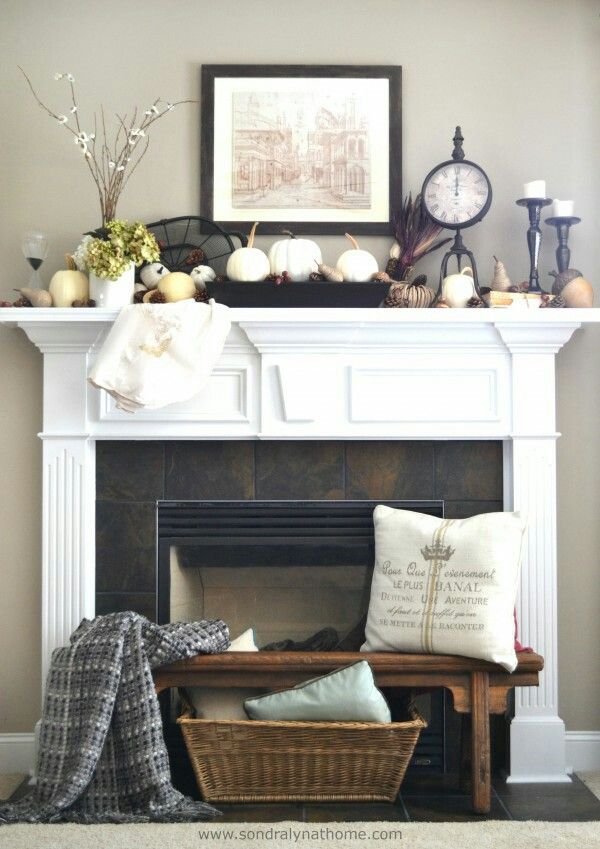 a living room filled with furniture and a fire place in front of a clock on top of a mantle