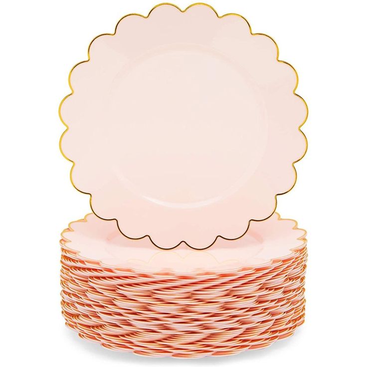 a stack of pink and gold plates with scalloped rims on top of each other