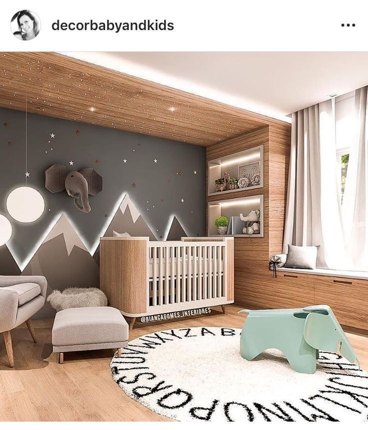 a baby's room with mountains painted on the wall and an elephant rug in the middle