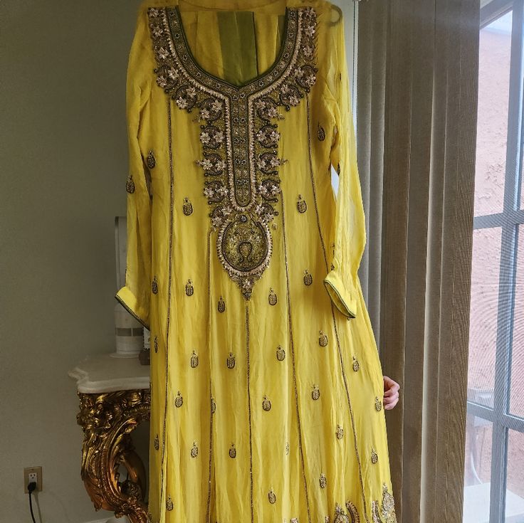 Here Is A Gorgeous Pakistani Fully Worked Dress In Yellow & Olive Green Velvet Border. The Work Consists Of Gotta & Stone Work In Various Sizes The Fabric Is In Pure Chiffon. Comes With A Trouser & Dupatta With Floral Stones Spray And Green Piping. It' A Small-Medium And Has Been Worn Only Once For A Few Hours. Its In Excellent Condition With No Wear Or Tear Practically Brand New. Comes In The Original Dustbag. Perfect For A Mehndi/Mayoon, Uptan Or Any Other Special Occasion. Pictures Don't Do J Traditional Yellow Floor-length Dress, Elegant Yellow Salwar Kameez With Intricate Embroidery, Yellow Wedding Dress With Dupatta, Yellow Floor-length Salwar Kameez With Intricate Embroidery, Yellow Silk Salwar Kameez With Intricate Embroidery, Floor-length Yellow Salwar Kameez With Intricate Embroidery, Yellow Floor-length Sets With Dabka Work, Elegant Yellow Salwar Kameez For Party, Yellow Resham Embroidered Dress For Wedding