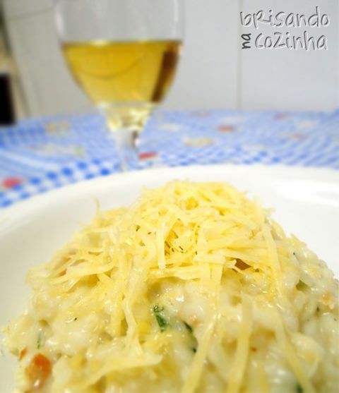 a white plate topped with macaroni and cheese next to a glass of wine