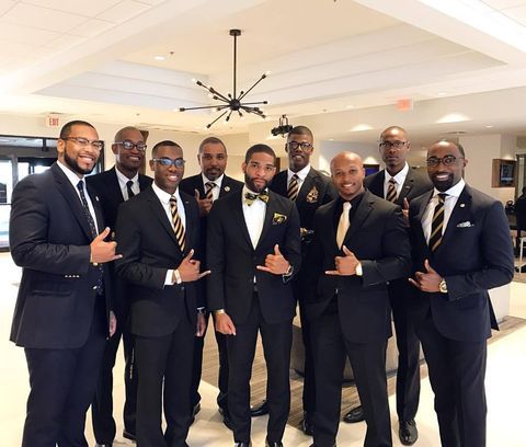 a group of men in suits and ties posing for the camera