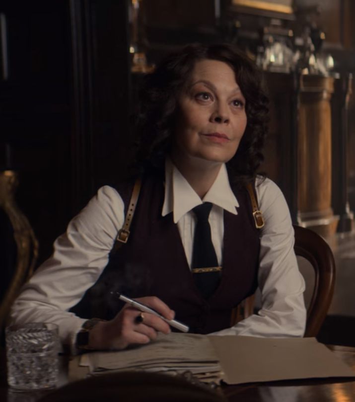 a woman sitting at a table with a pen in her hand