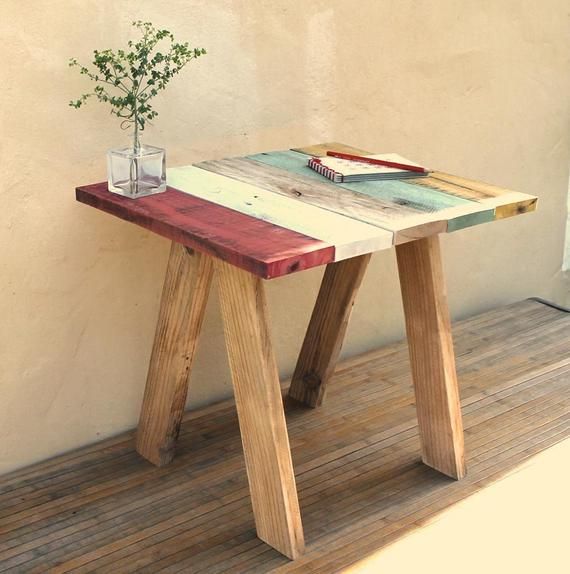 a small wooden table sitting on top of a hard wood floor next to a wall