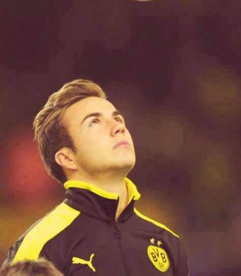 a young man is looking up at the sky with his eyes closed while wearing a black and yellow jacket