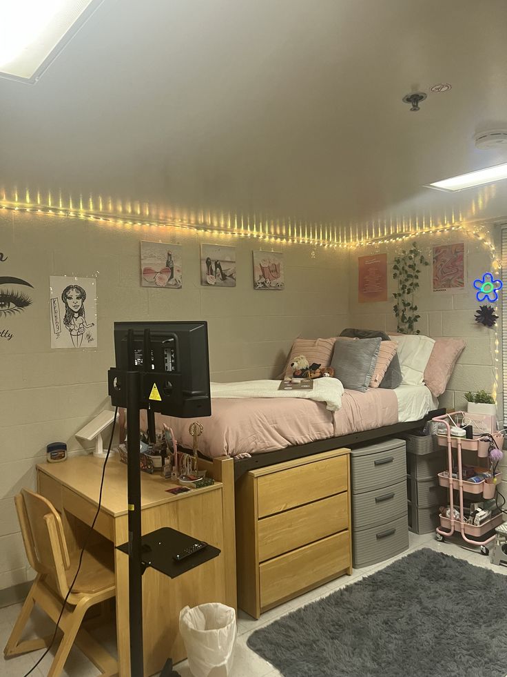 a dorm room with a bed, desk and computer on top of the dressers