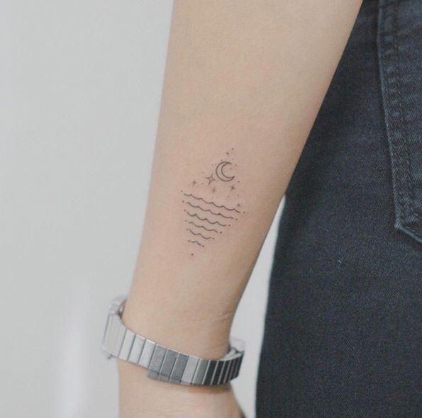 a woman's arm with a small wave tattoo on it