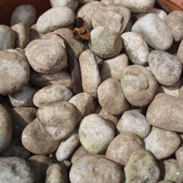 some rocks in a brown pot on the ground