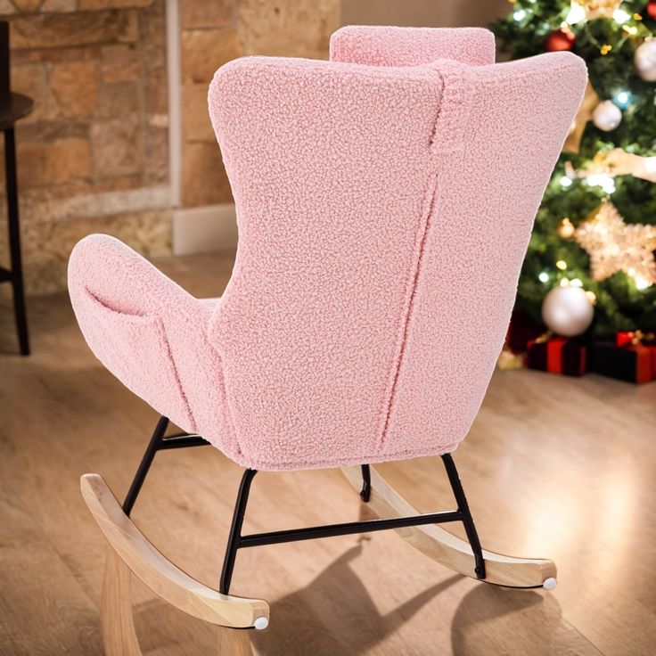 a pink rocking chair in front of a christmas tree