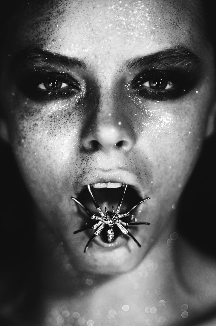 a woman with her mouth open and a spider on it's face in black and white