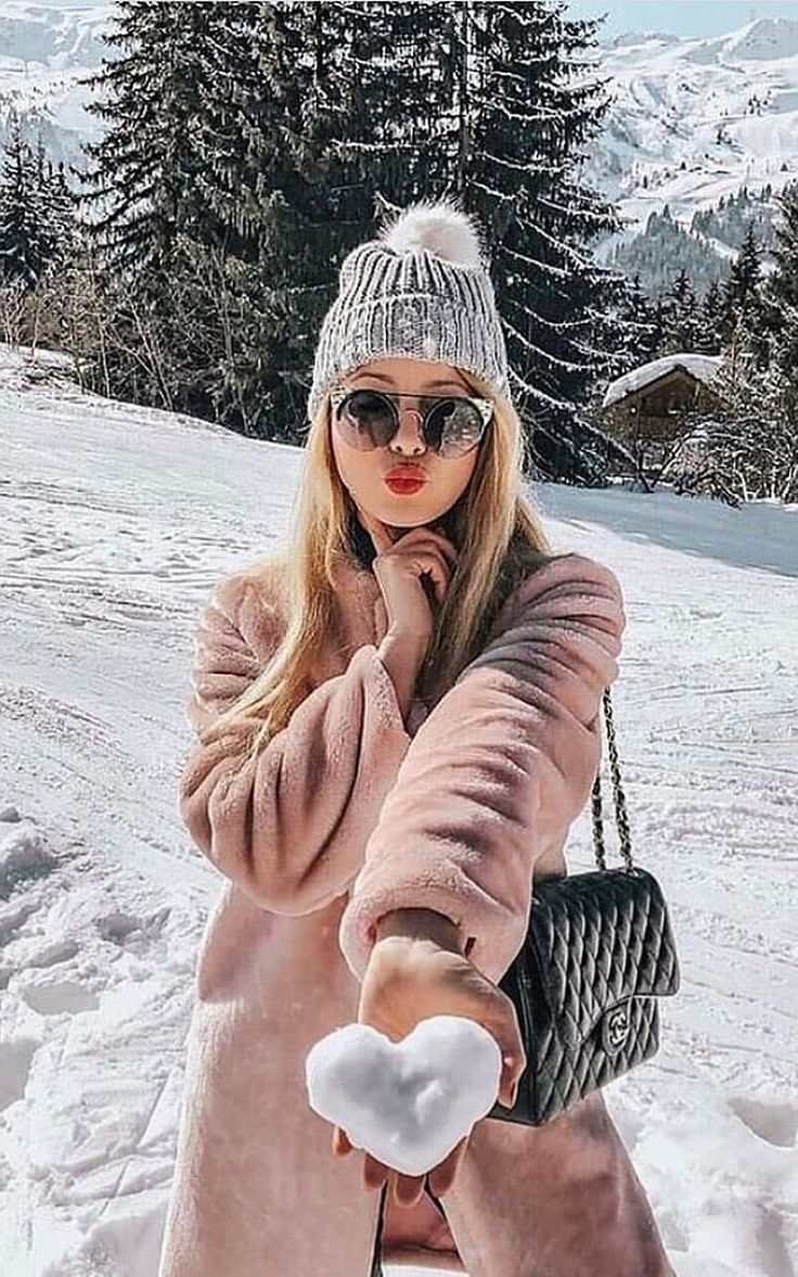 a woman is standing in the snow with her hand on her face