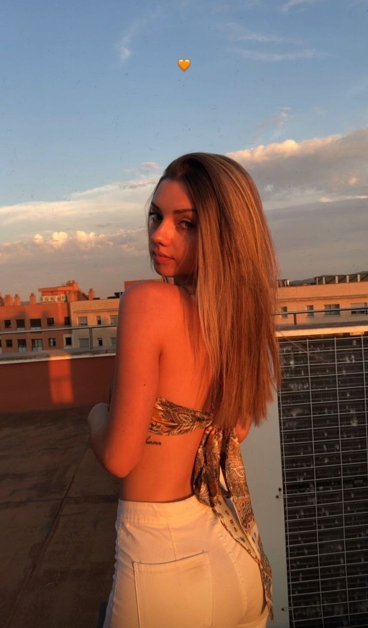 a woman standing on top of a roof next to a hot air balloon