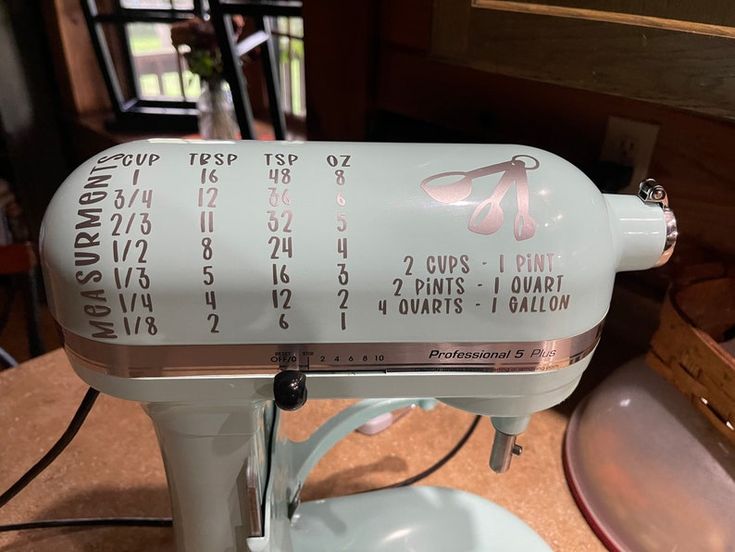 a white mixer sitting on top of a wooden table