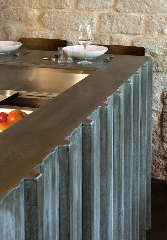 a kitchen counter with plates and bowls on it next to a brick wall in the background