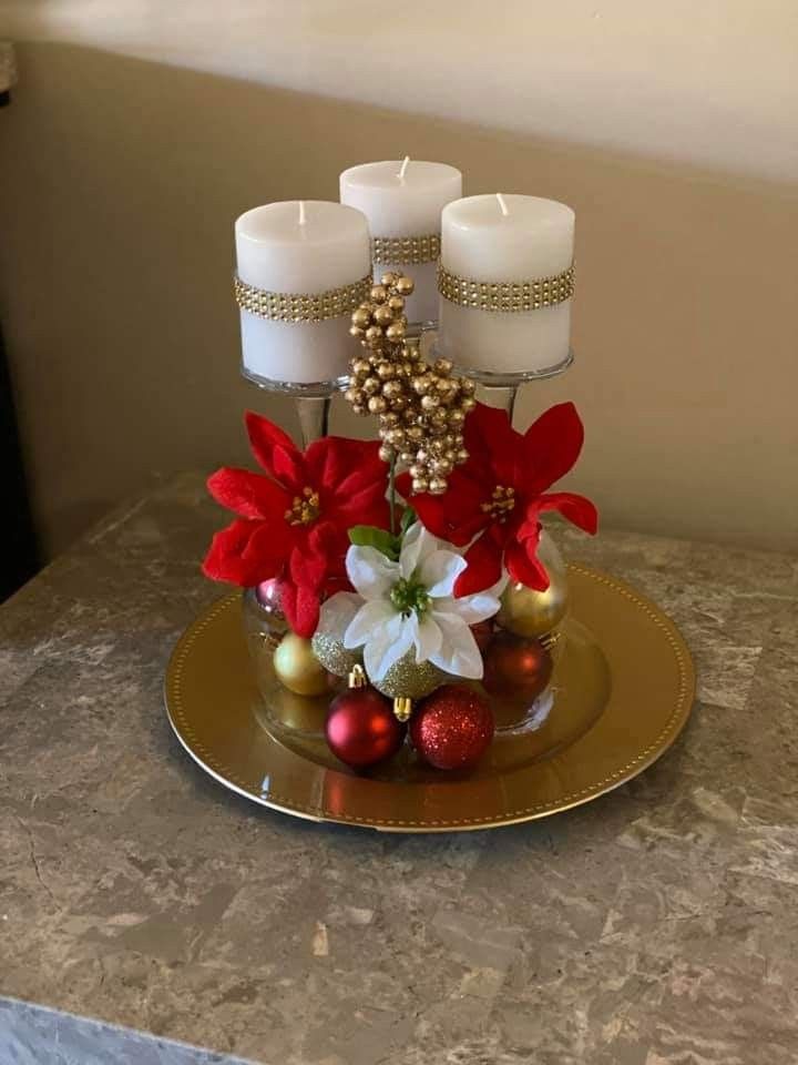 a table topped with candles and ornaments on top of a gold plate