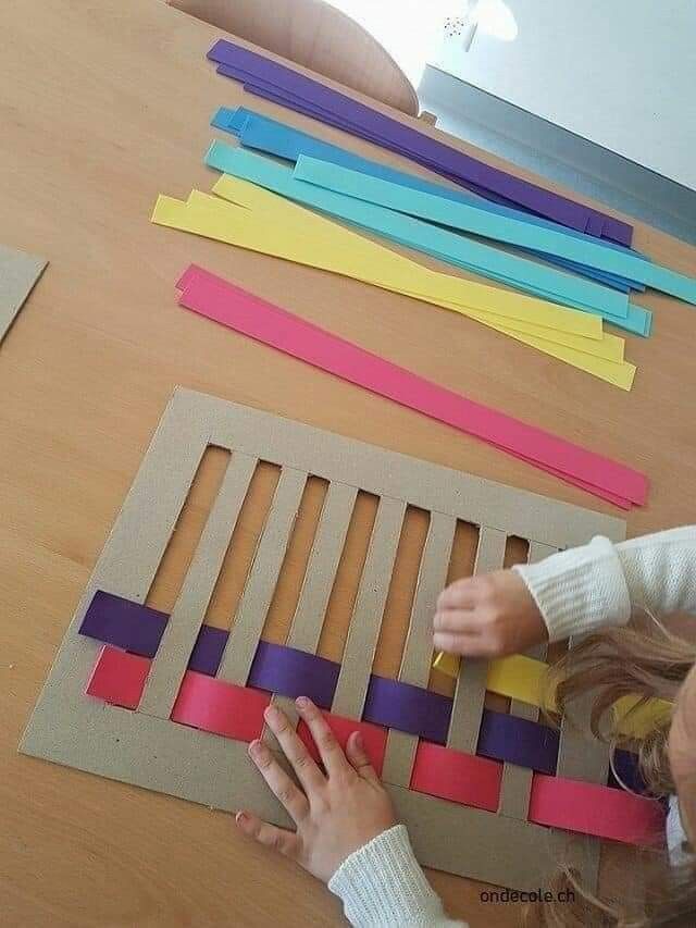 two children are playing with colored paper on the floor