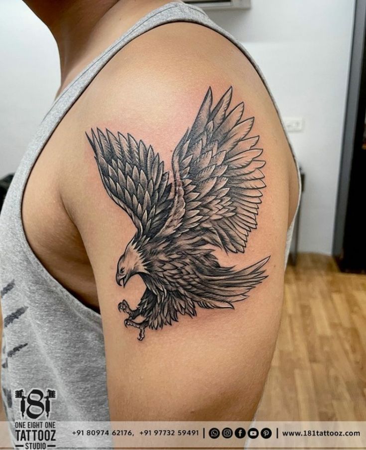 a man with a black and grey eagle tattoo on his arm