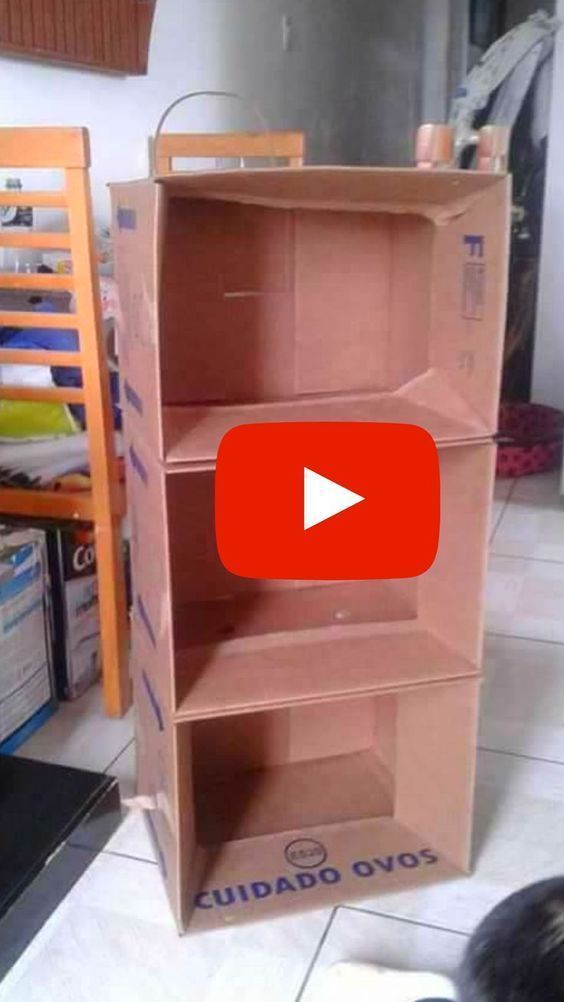 a cardboard book shelf sitting on top of a white tile floor next to a black cat