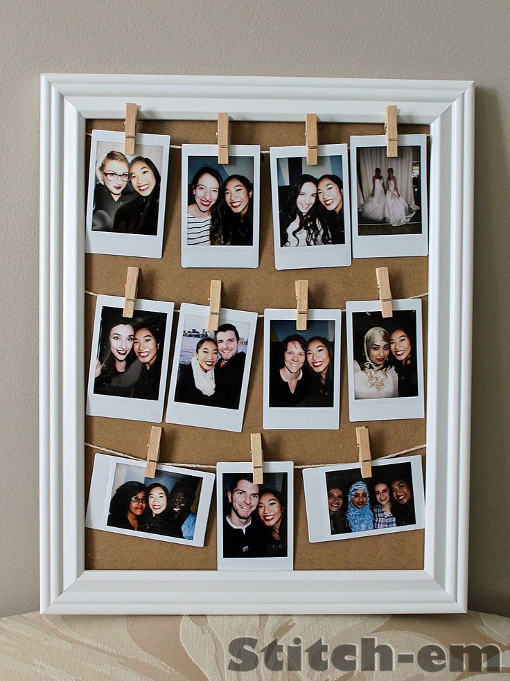 a white frame with photos pinned to clothes pins