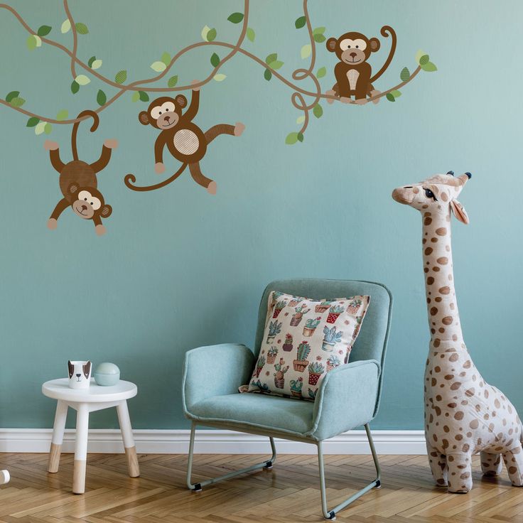 a baby's room decorated with monkeys and giraffes on the wall