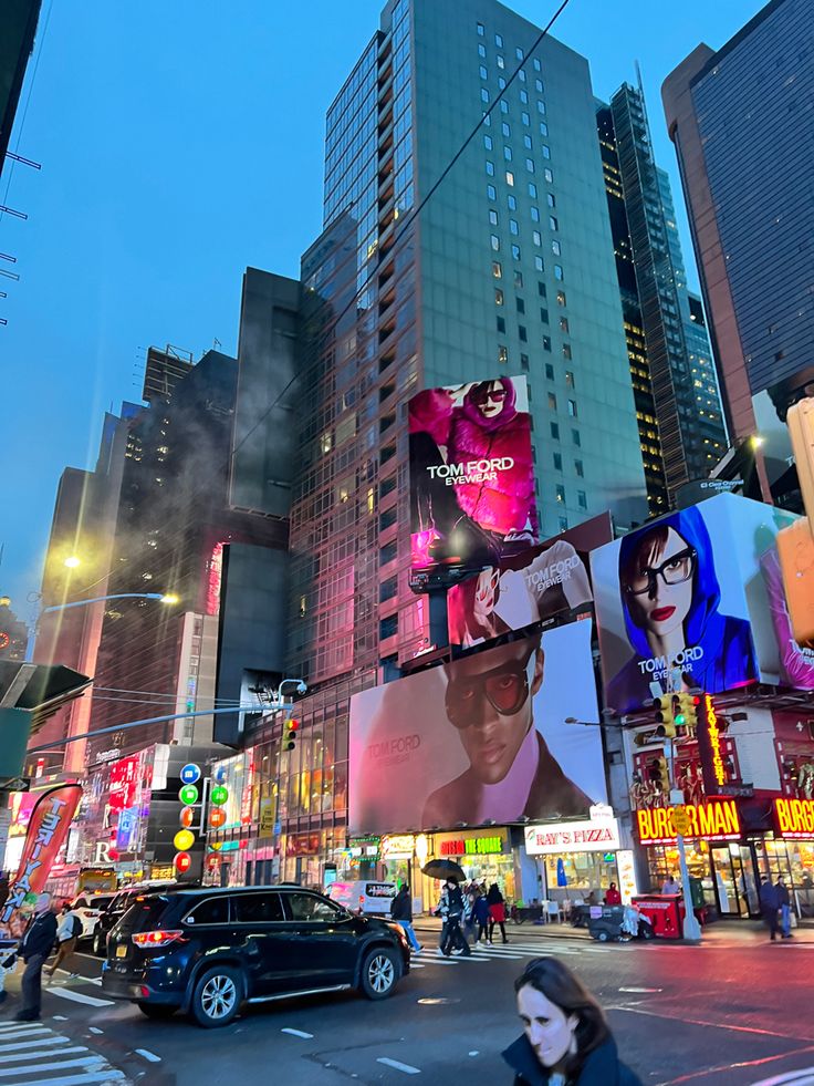 a busy city street at night with tall buildings and billboards on the side of it