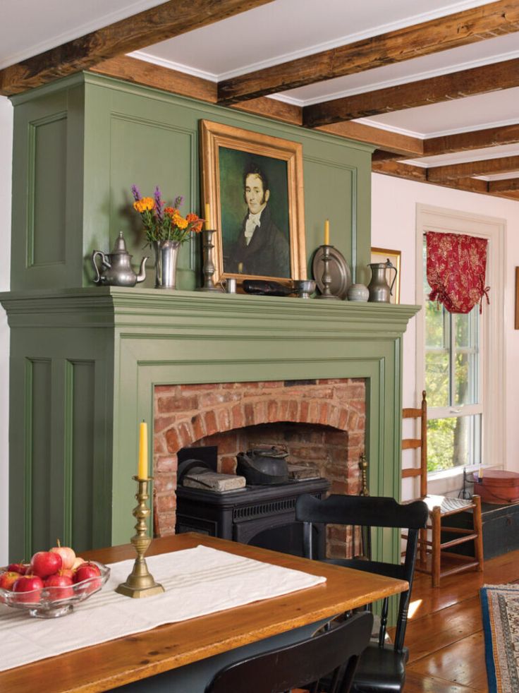 a fireplace in a living room next to a table with fruit and candles on it