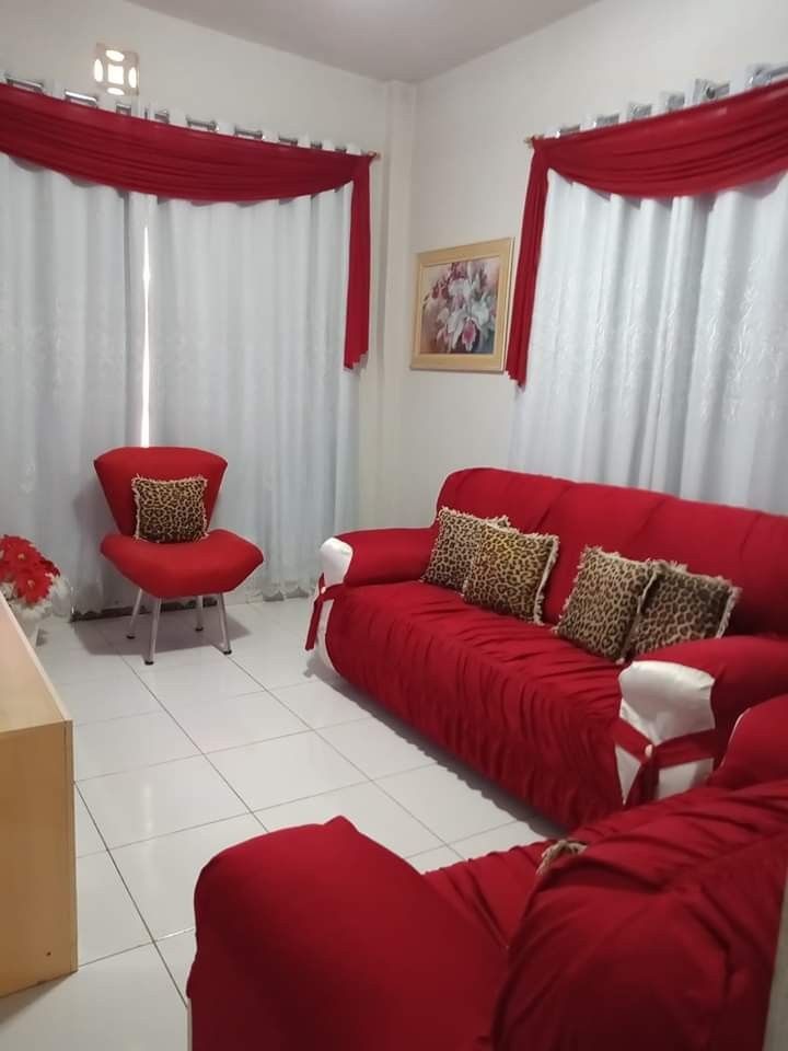 a living room filled with red couches and chairs next to a white tiled floor