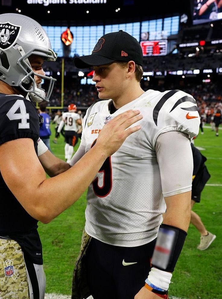 two football players standing next to each other on a field