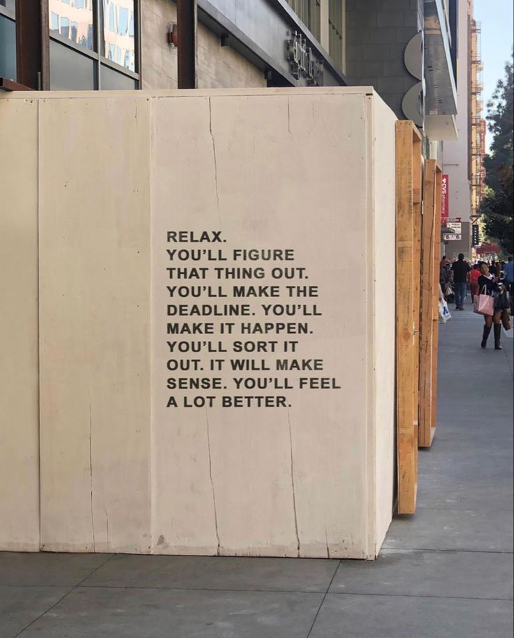 a sign on the side of a building that says relax you'll figure that thing out