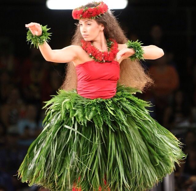 a woman in a hula skirt on the runway