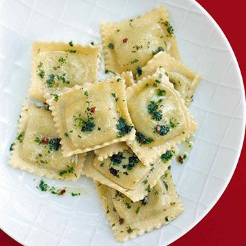 a white plate topped with ravioli and broccoli