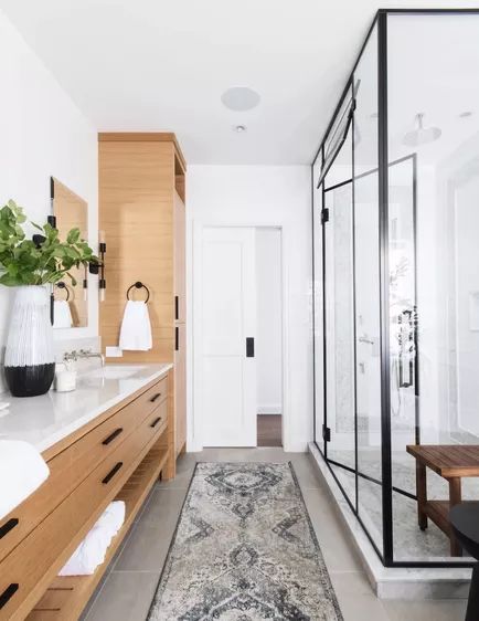 a large bathroom with wooden cabinets and white walls