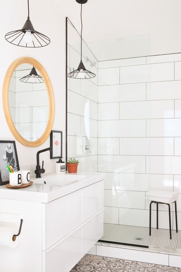 a bathroom with white tile and black fixtures