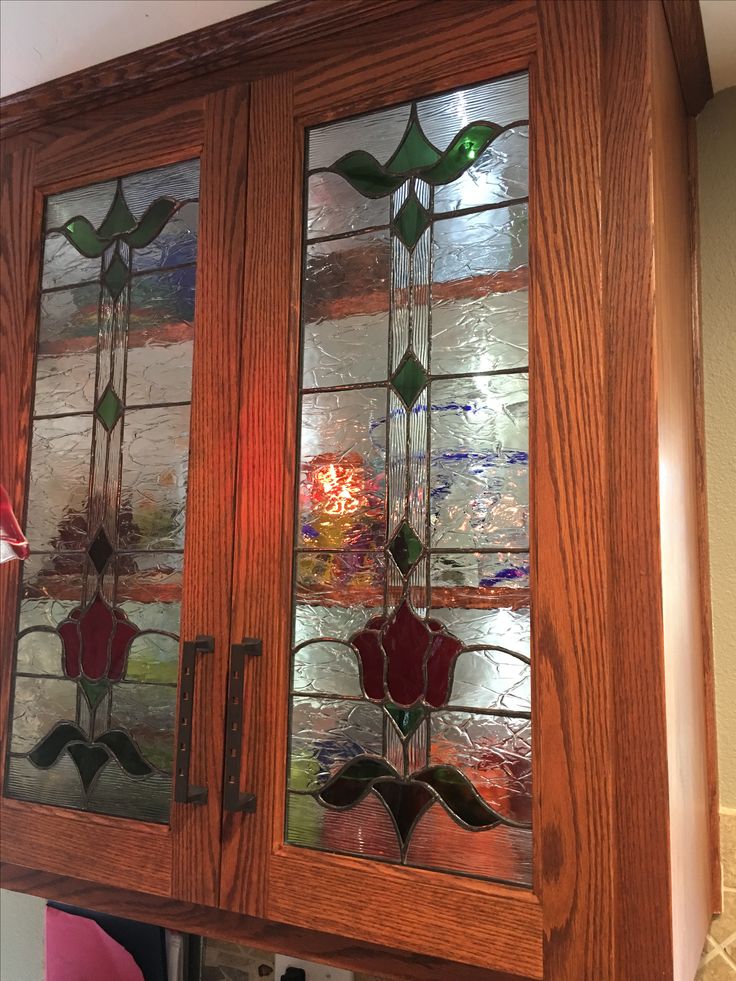 a wooden cabinet with stained glass doors