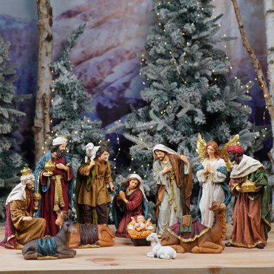 a group of figurines sitting on top of a table next to a christmas tree