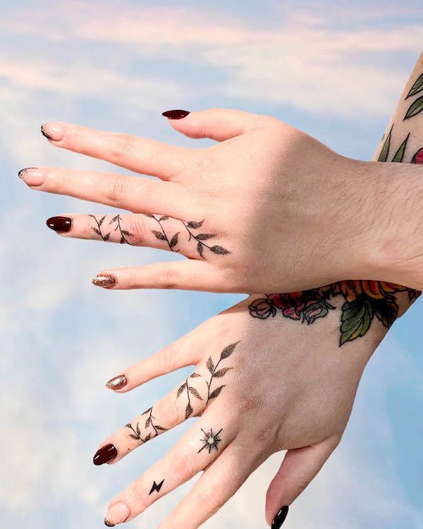 two female hands with tattoos on their fingers