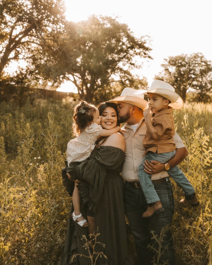 a man, woman and child are posing for a photo in a field with trees