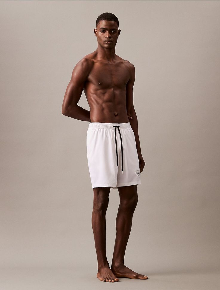 Made with solid styling, these swim shorts are made with quick-dry fabric perfect for the sand and the sun. Detailed with a drawstring elasticated waistband, a retro-inspired monogram logo and a 7" inseam. White Nylon Swim Trunks For Beach Season, White Nylon Swim Trunks, White Nylon Short Swim Trunks, Short White Nylon Swimwear, White Moisture-wicking Beachwear Bottoms, White Activewear With Elastic Waistband For Beach, White Sporty Swim Trunks With Drawstring, White Athleisure Swim Trunks Short Length, Sporty White Swim Trunks With Drawstring