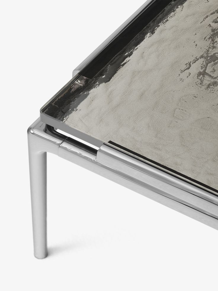 a close up of a metal table with a black and white painting on it's surface