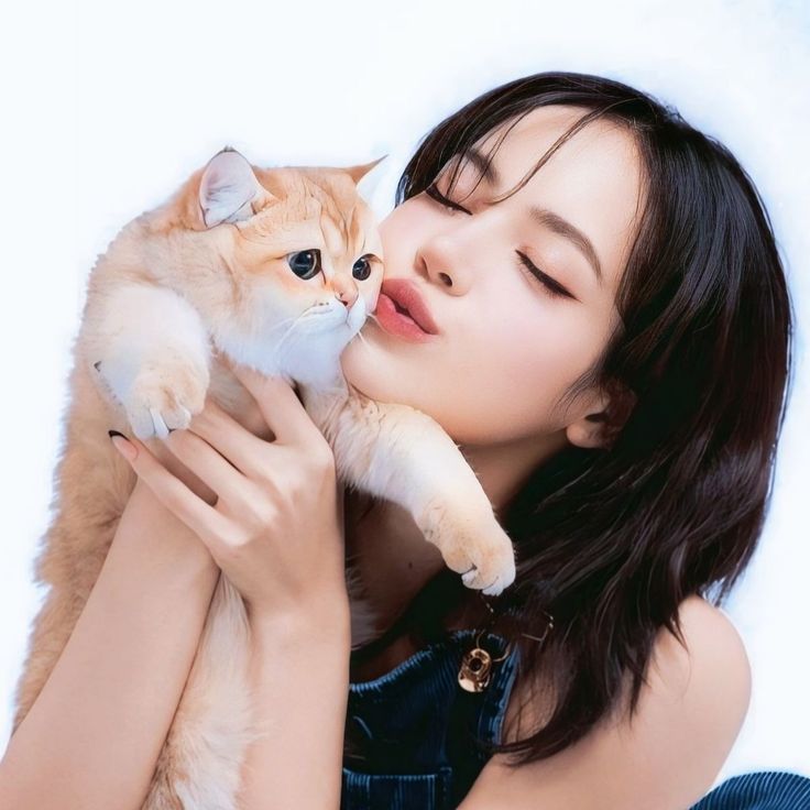 a woman holding a cat up to her face