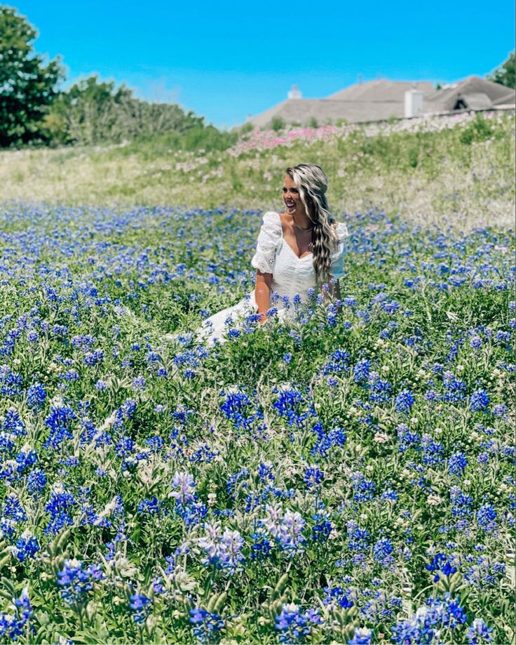 a woman in a field full of blue flowers