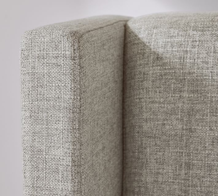 a close up view of the back end of a couch with white walls in the background