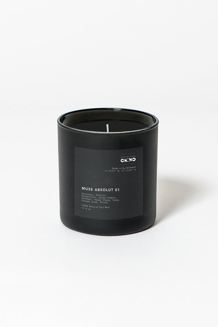 a black candle sitting on top of a white table