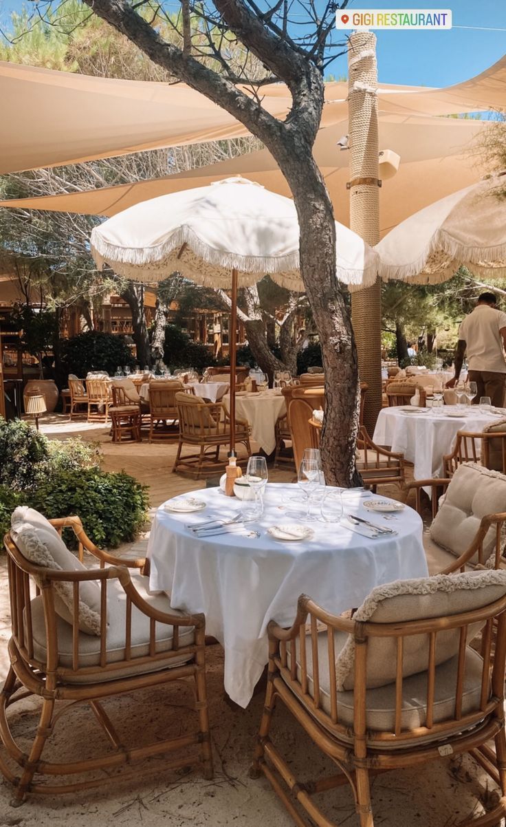 an outdoor dining area with umbrellas and tables set up for two people to eat